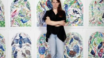 Artist and her work hanging behind her