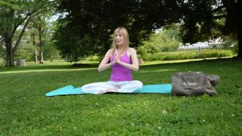 Yoga teacher sitting outdoors on the grass