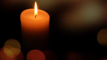 Candle burning in darkness
